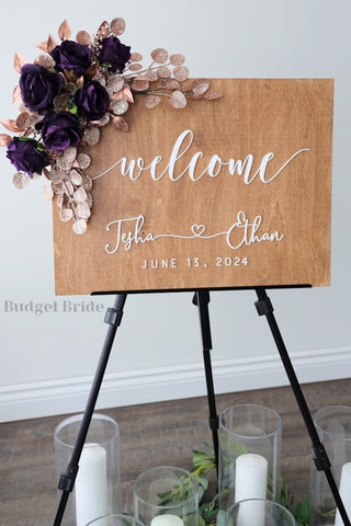 Wedding Sign Flowers that easily accent flowers to attach to a standing easle wedding sign to be used at ceremony or reception in plum and rose gold glitter 